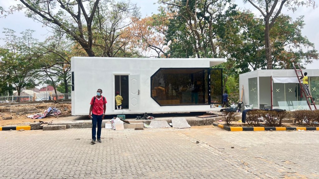 Capsule home installation on interlocking paver foundation with crew on site