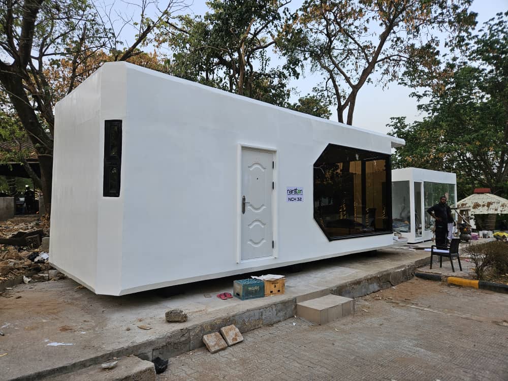 White NCH32 capsule home installed among trees with Nanston branding