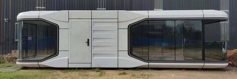 Capsule home with panoramic glazing at industrial warehouse facility